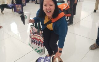 Christina smiles while standing with a certified pup from Alliance of Therapy Dogs.