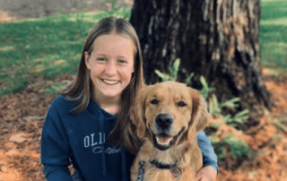 Student volunteer poses with golden retriever