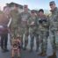 Therapy dog Finlea and her handler pose for a group photo with members of the military.