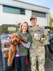 Therapy dog Finlea and her handler pose for a photo with military personnel.